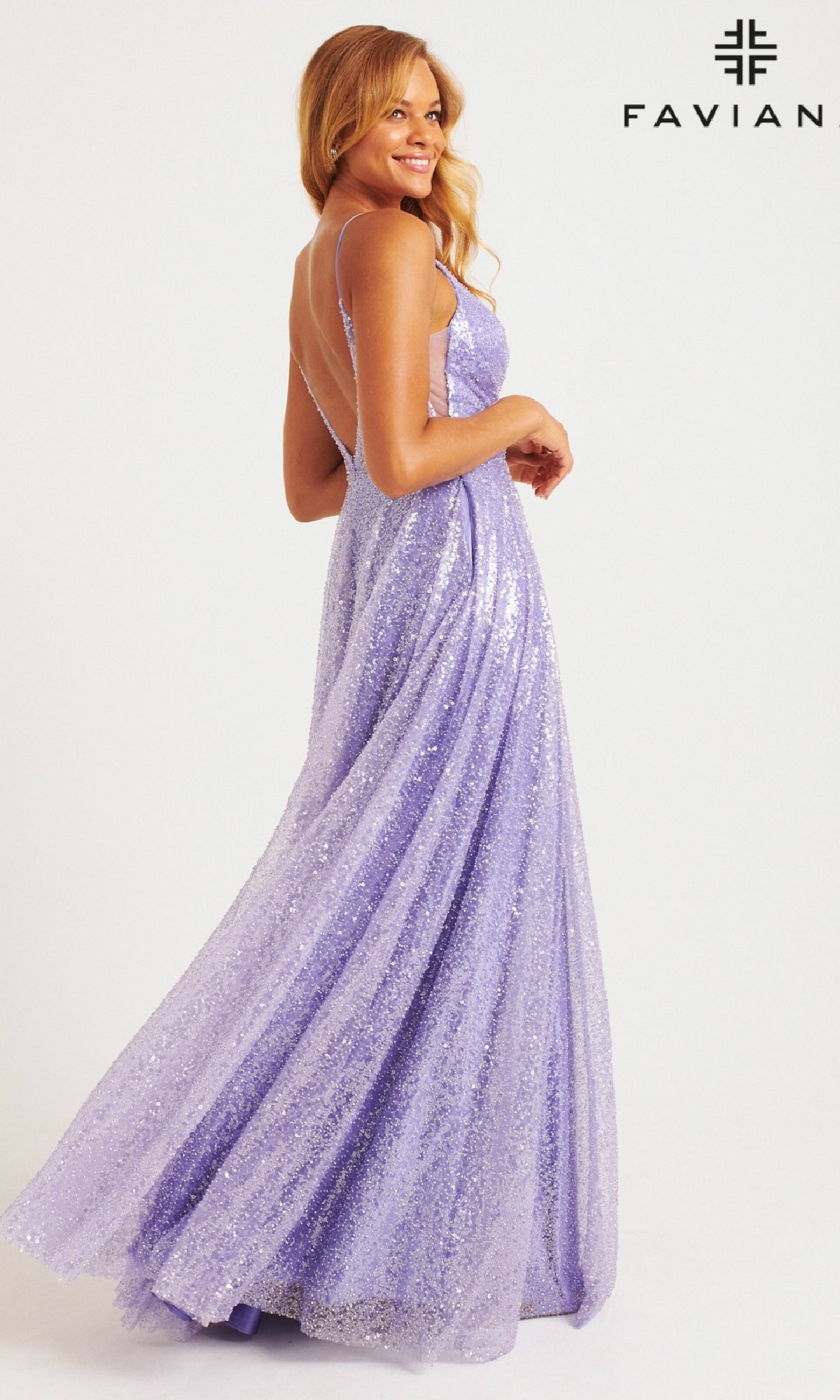 A woman smiles and poses in a sparkly lavender Faviana 11203 Long Sequin A-Line Prom Dress with thin straps against a plain white background, with the Faviana logo featured in the top right corner.